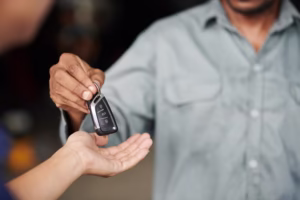 Closeup image of mechanic giving car keys to client